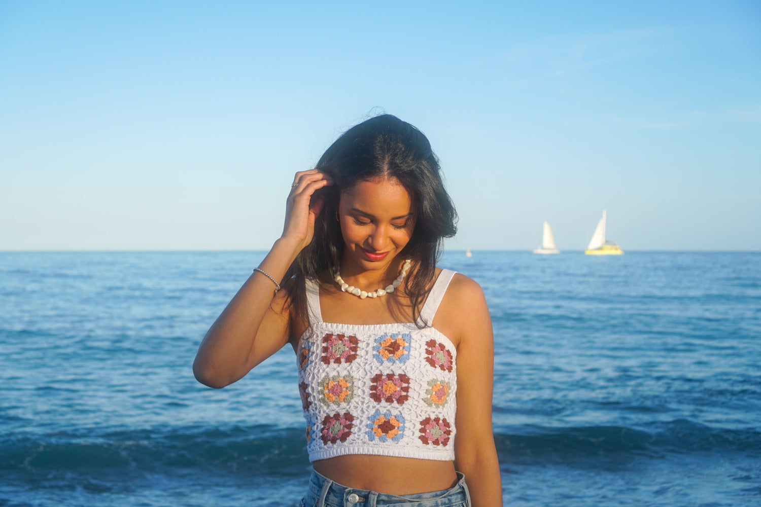 Junge Frau am Strand trägt Perlenkette vom Schmucklabel Ositoclub 